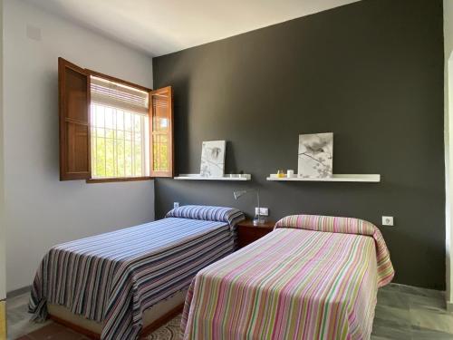 2 camas en una habitación con paredes verdes en Casa de campo "La Campanera", en Constantina