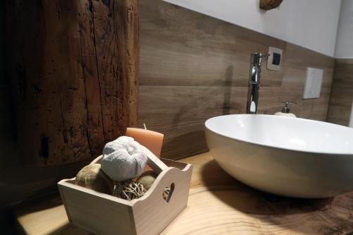 a bathroom with a sink and a bath tub and a box with towels at Malga Laben in Velo Veronese