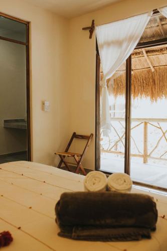 a bedroom with a bed and a large window at Xiknal Cozumel in Cozumel