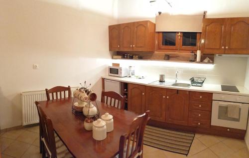 a kitchen with a wooden table with chairs and a kitchen with a counter at Ξενώνας Το Πατρικό in Karya