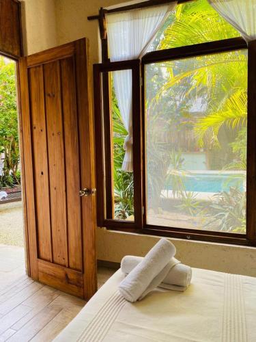 a bedroom with a window and a bed with towels on it at Xiknal Cozumel in Cozumel