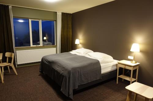 a hotel room with a bed and a window at Basalt Hotel in Borgarnes