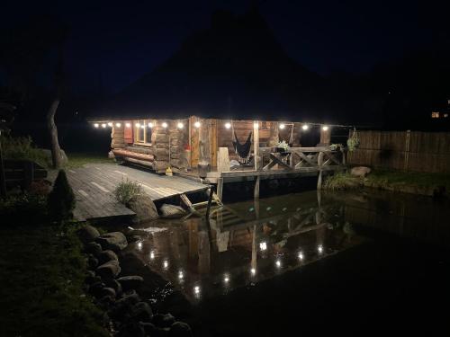 a log cabin lit up at night with lights at Pirtiņa in Ogre
