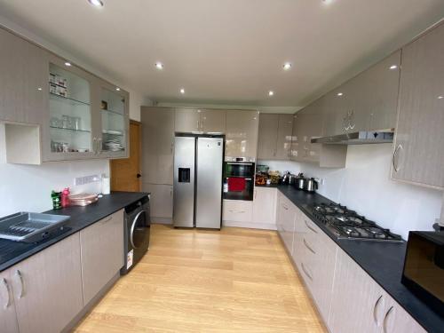 a kitchen with white cabinets and a stainless steel refrigerator at Double Bedroom with en-suite shower & free parking in Belvedere