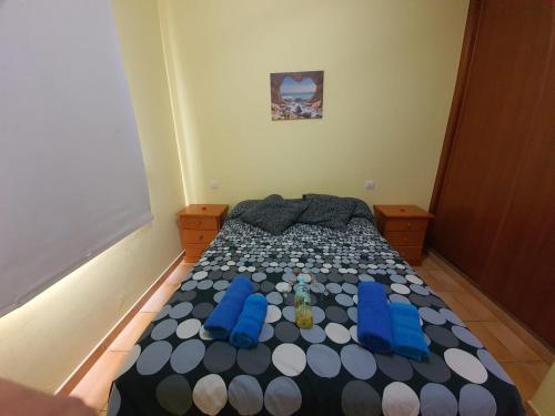 a small bedroom with a bed with blue chairs at EL ERIZO in Caleta de Sebo