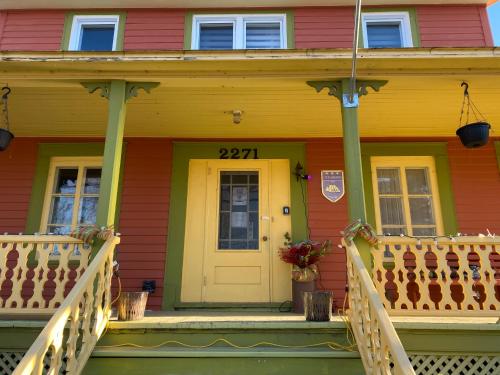 a yellow door on a house with a porch at Gite de la Baie Hatée in Bic