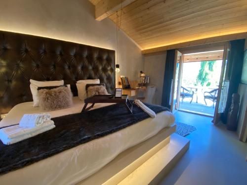 um quarto com uma cama grande e uma grande cabeceira de couro em Lodge Jardin Secret - Propriétés Mont Amour em Montriond
