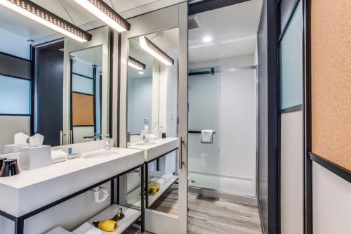a bathroom with two sinks and a shower at Aloft Dallas Arlington Entertainment District in Arlington