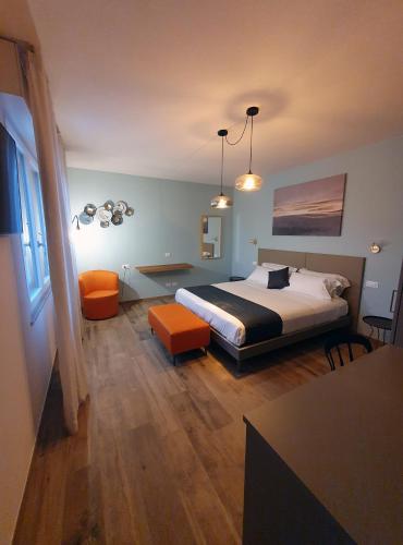 a bedroom with a bed and an orange chair at La Lampara in Sirmione