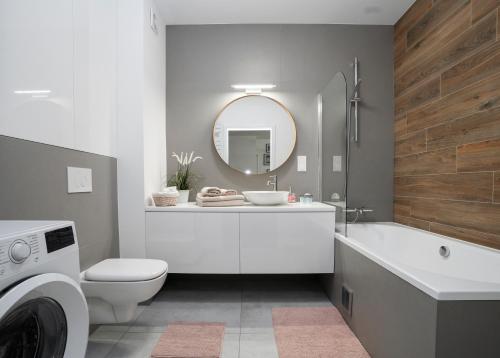 a bathroom with a sink and a tub and a toilet at Apartament AQUAROOM Reda in Reda