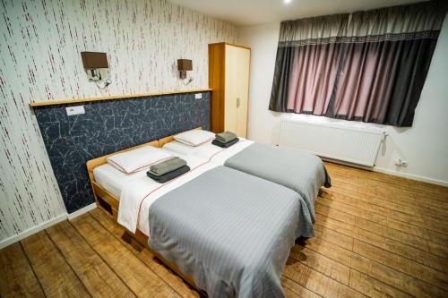 um quarto de hotel com uma cama com lençóis brancos em Vila Phoenix em Călimăneşti