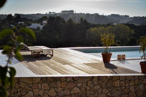 a swimming pool with a wooden deck next to a house at Casa-Simplicity 