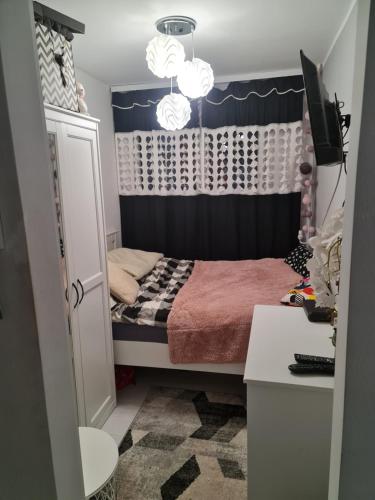 ein kleines Schlafzimmer mit einem Bett und einem Vorhang in der Unterkunft Apartament przy Kopalni Złota in Złoty Stok