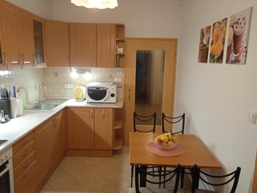 a small kitchen with a table and a microwave at Family apartment-családias hangulat in Győr
