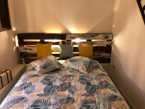 ein Bett mit zwei Kissen auf einem Zimmer in der Unterkunft Chez Julien: appartement confort plein centre in Lunéville