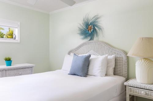 a bedroom with a white bed with a blue feather on the wall at Gulf View Waterfront Resort in Marathon