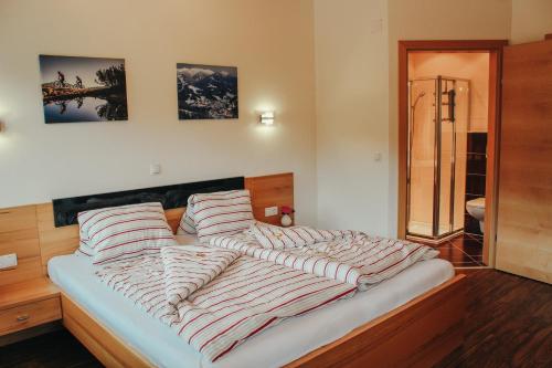 a large bed with striped pillows in a bedroom at Siegi's Apartments in Hof