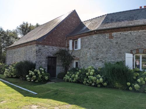 an old stone house with a grass yard at La Grange de Dourlers in Dourlers