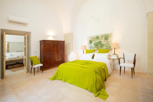 1 dormitorio con cama, escritorio y espejo en Masseria Luci, en Maglie