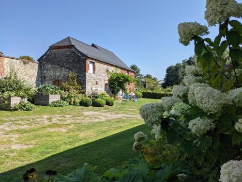 an old stone building with flowers in a garden at La Grange de Dourlers in Dourlers