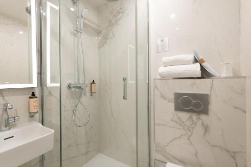 a bathroom with a shower, sink, and toilet at HOTEL AU COEUR DE REPUBLIQUE in Paris