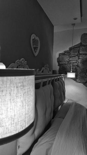 a bedroom with a bed and a stone wall at B&B La casa dei cuori in Millesimo