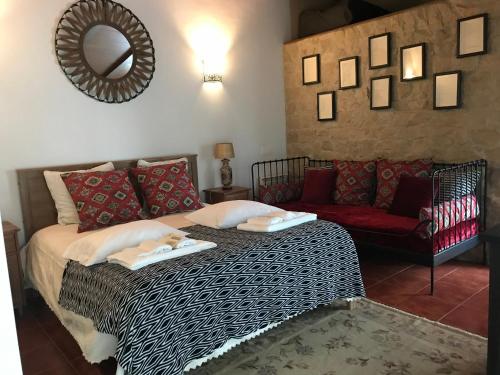 a bedroom with a bed and a red couch at Casal das Nogueiras, casas rurais de charme agradáveis e acolhedoras in Arrimal