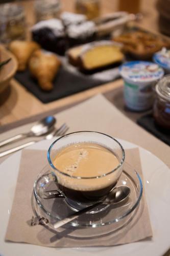 a cup of coffee on a plate on a table at Pimont Alpine Chalet in Madonna di Campiglio