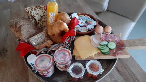 een dienblad met eten, eieren, brood en drinken bij Bed en Breakfast The Wooden Wall in Marum