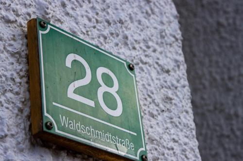 a green street sign on the side of a building at Apartments Haus Martin in Bayerisch Eisenstein