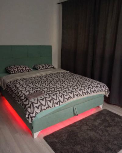 a bedroom with a bed with a red light on it at Park Apartment in Foča