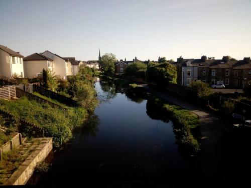 a view of a river in a city with houses at The Staithe by the Canal. in Lancaster