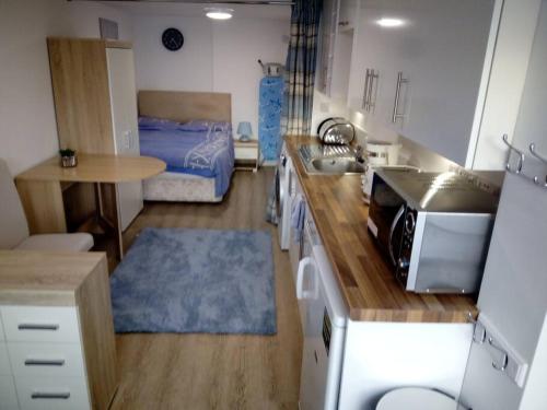 a kitchen with a sink and a bed in a room at The Staithe by the Canal. in Lancaster