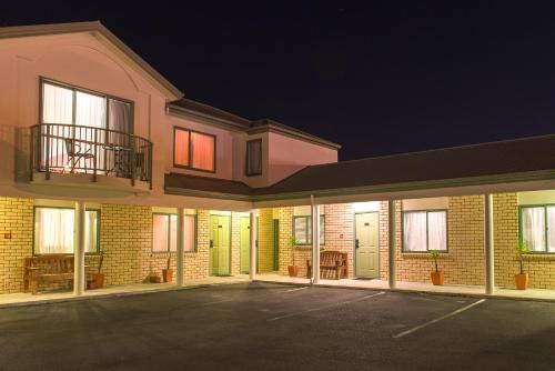 an empty parking lot in front of a building at Hamilton Settlers Motor lodge in Hamilton