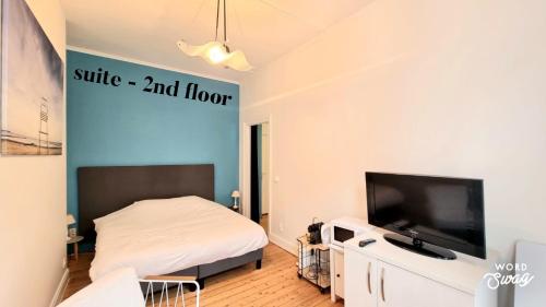 een slaapkamer met een bed en een flatscreen-tv bij Studio Heyst in Knokke-Heist