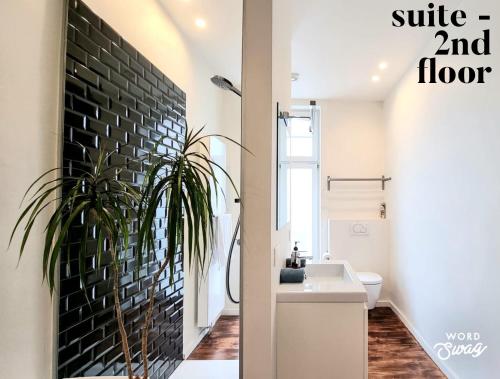 a bathroom with a sink and a black brick wall at Studio Heyst in Knokke-Heist