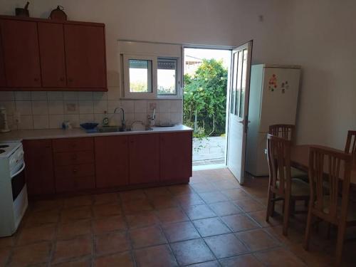a kitchen with a sink and a table and a refrigerator at Antonia's Rustic Retreat in Dhórion