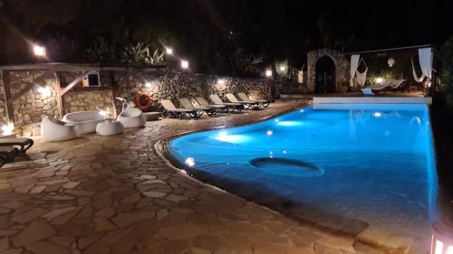 a swimming pool at night with chairs and lights at Villa Le Agavi & Spa in Scarlino