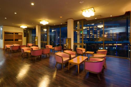 a restaurant with tables and chairs and windows at kinugawaonsen Fukumatsu in Nikko