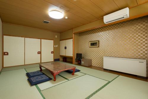 a room with a table in the middle of a room at kinugawaonsen Fukumatsu in Nikko