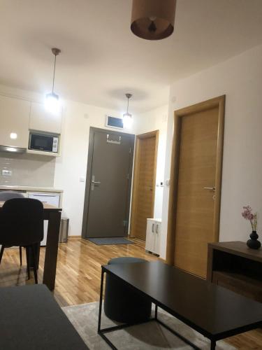 a living room with a table and a door at Apartman Kraljevi čardaci Makica Kopaonik sa garazom in Kopaonik