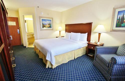 a hotel room with a bed and a couch at Baymont by Wyndham Flagstaff in Flagstaff