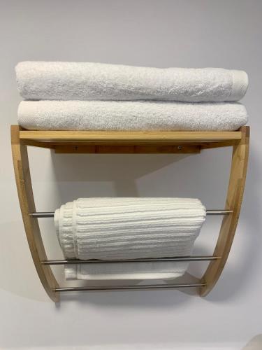 a towel rack with towels on a shelf at Puerta de Caceres Apartamento 1 in Cáceres