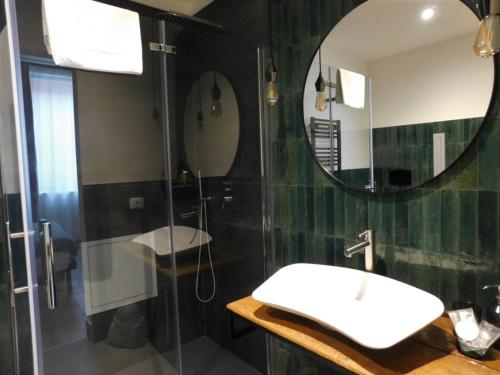 a bathroom with a sink and a mirror at Piumaviola Beds & Apartments in Parma