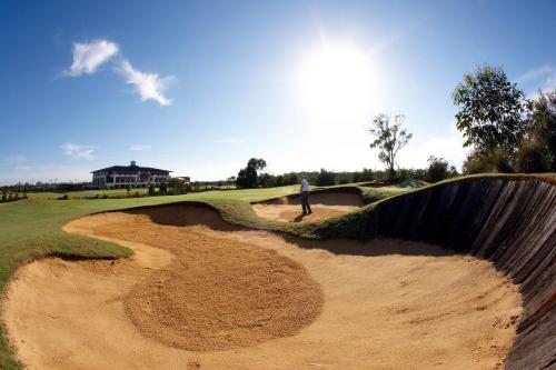 a man is standing on a bunker on a golf course at Mercure Kooindah Waters Central Coast in Wyong