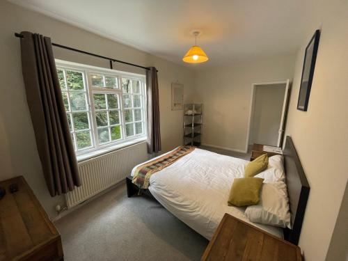 een slaapkamer met een bed en een raam bij Garden House in Nailsworth