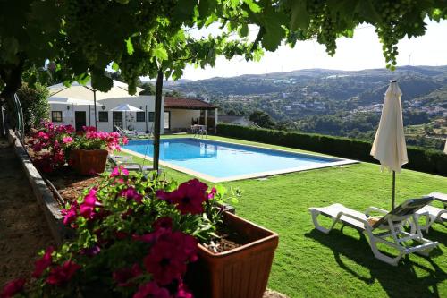 
a patio area with a pool and lawn chairs at Quinta da Timpeira in Lamego

