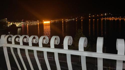 a white fence with a view of the water at night at Bujtina Xhabakja in Belsh-Qendra