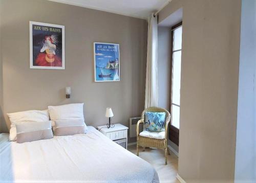 um quarto com uma cama, uma cadeira e uma janela em Studio Meublé L'Orée du Parc em Aix-les-Bains