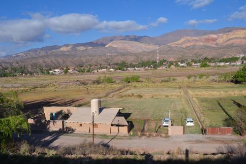 a building in a field with mountains in the background at Cabañas Sixilera in Huacalera